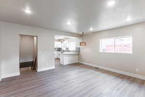 Family room with a textured ceiling, light wood-style flooring, and recessed lighting