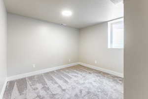 Bedroom with light colored carpet and a textured ceiling