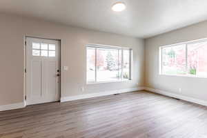 Foyer with a textured ceiling and light wood-type flooring