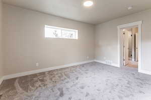 Master bedroom with light colored carpet and baseboards