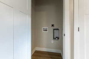 Laundry in master bedroomarea with dark wood finished floors, washer hookup, and electric dryer hookup