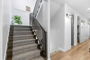Stairway featuring wood finished floors and baseboards