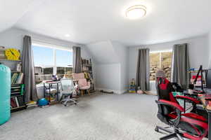 Home office featuring lofted ceiling, carpet floors, and plenty of natural light