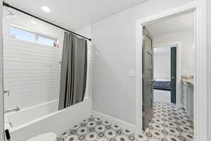 Ensuite bathroom featuring shower / bath combo with shower curtain, vanity, and recessed lighting