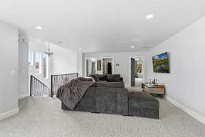 Carpeted living area featuring recessed lighting and a chandelier