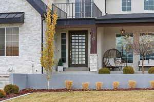 Property entrance with stone siding and stucco siding