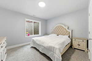 Bedroom featuring light colored carpet