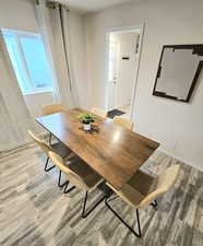 Dining area with light wood-style floors and healthy amount of natural light