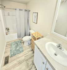 Full bath featuring light wood finished floors, vanity, and shower / bath combo with shower curtain
