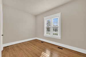 Empty room featuring baseboards and light wood finished floors
