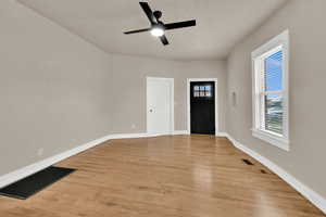 Foyer entrance with light wood-type flooring and a ceiling fan