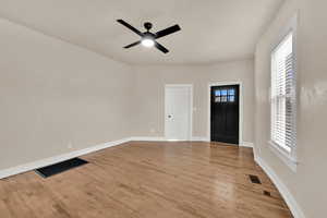 Entrance foyer with light wood finished floors and a ceiling fan