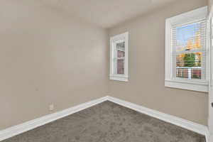 Spare room featuring baseboards and carpet flooring