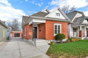 View of front of home with brick siding and roof with shingles