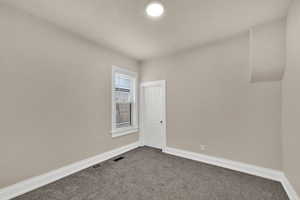Spare room featuring carpet floors and baseboards