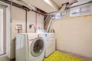 Washroom featuring unfinished concrete flooring and separate washer and dryer