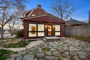 Rear view of property featuring a fenced backyard, a chimney, and a patio