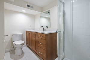 Bathroom featuring light tile patterned floors, vanity, and a stall shower