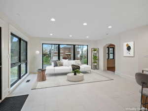 Living area with arched walkways, recessed lighting, and healthy amount of natural light