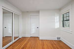 Unfurnished bedroom with light wood finished floors and a closet