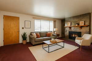 Carpeted living area featuring a stone fireplace. Virtually staged