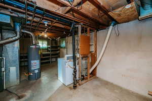 Unfinished basement featuring gas water heater, washer / clothes dryer, and heating unit