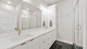 Bathroom with double vanity, a stall shower, and dark marble finish flooring