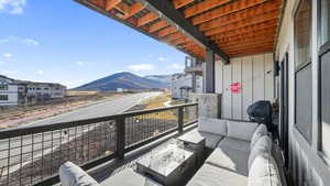 Balcony featuring an outdoor hangout area, a mountain view, a sunroom, and a grill
