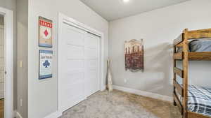 Bedroom with light colored carpet and a closet