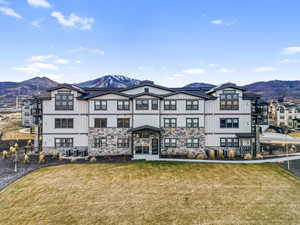 Rear view of property with a mountain view, a lawn, and board and batten siding
