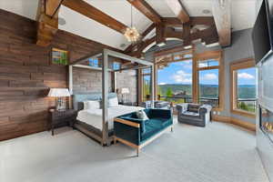 Bedroom featuring wood walls, carpet, access to outside, and a glass covered fireplace