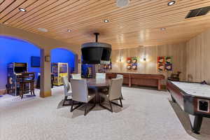Dining area with arched walkways, wooden ceiling, carpet, and recessed lighting