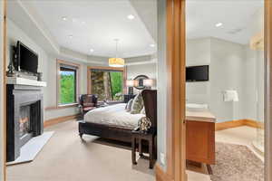 Bedroom featuring recessed lighting, a glass covered fireplace, and light carpet
