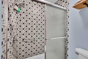 Full bathroom featuring toilet and a stall shower