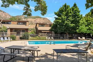 Community pool with a patio area and a mountain view
