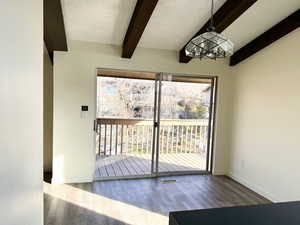 Doorway to outside featuring wood finished floors and beamed ceiling