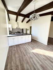 Kitchen with decorative backsplash, white cabinets, stainless steel appliances, a textured ceiling, and light wood-style flooring