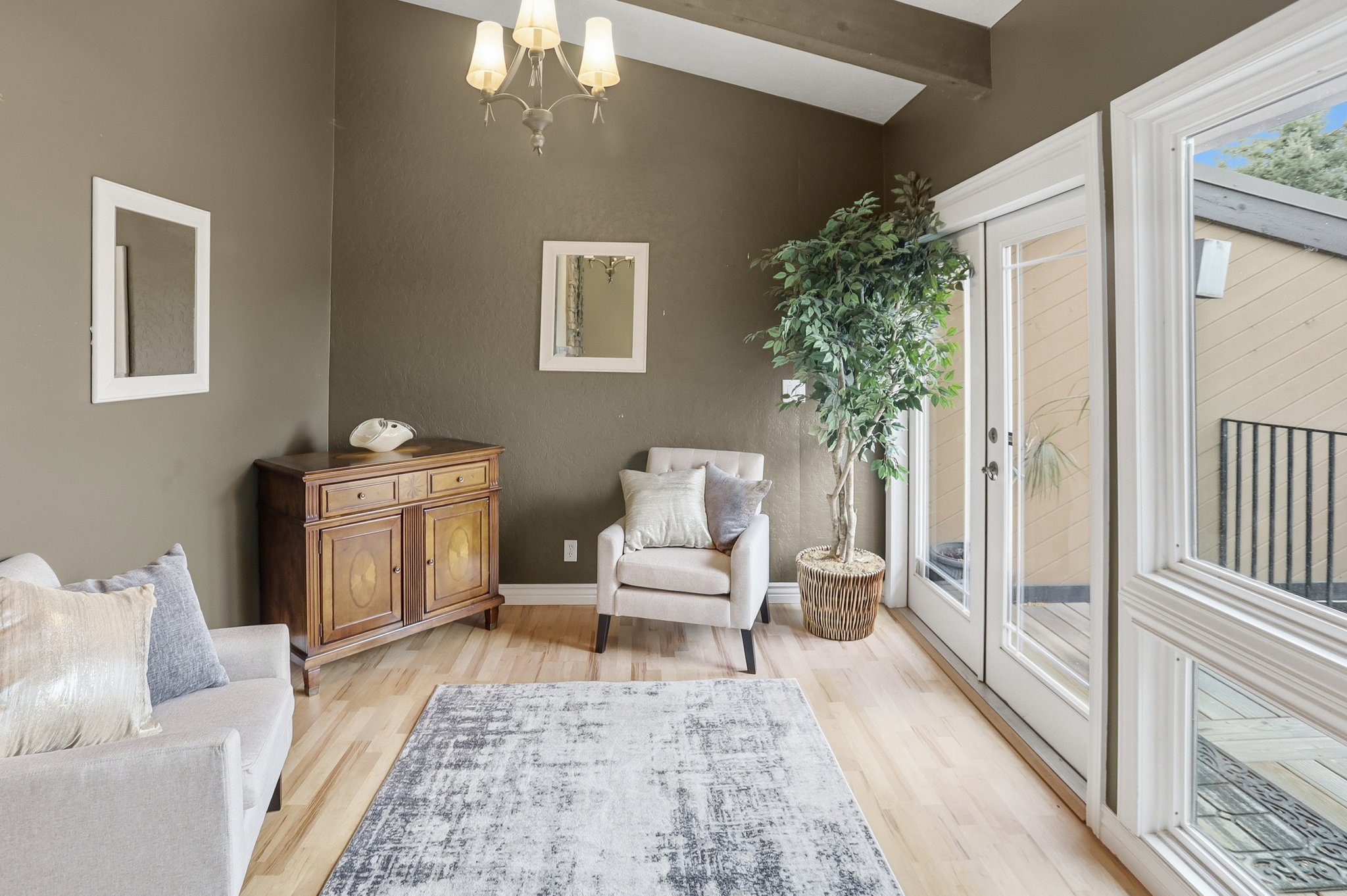 Sitting room featuring a chandelier, light wood-style flooring, and french doors