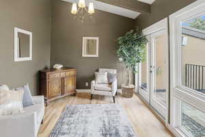 Sitting room featuring a chandelier, light wood-style flooring, and french doors