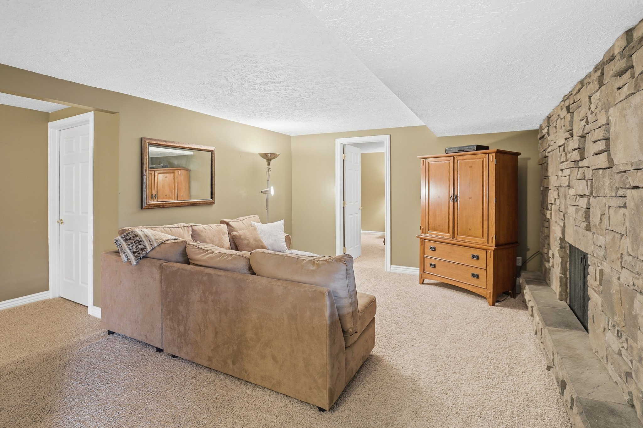 Living area with a textured ceiling, light carpet, and a fireplace