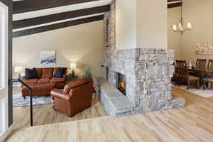 Living room featuring a fireplace, light wood finished floors, and a chandelier