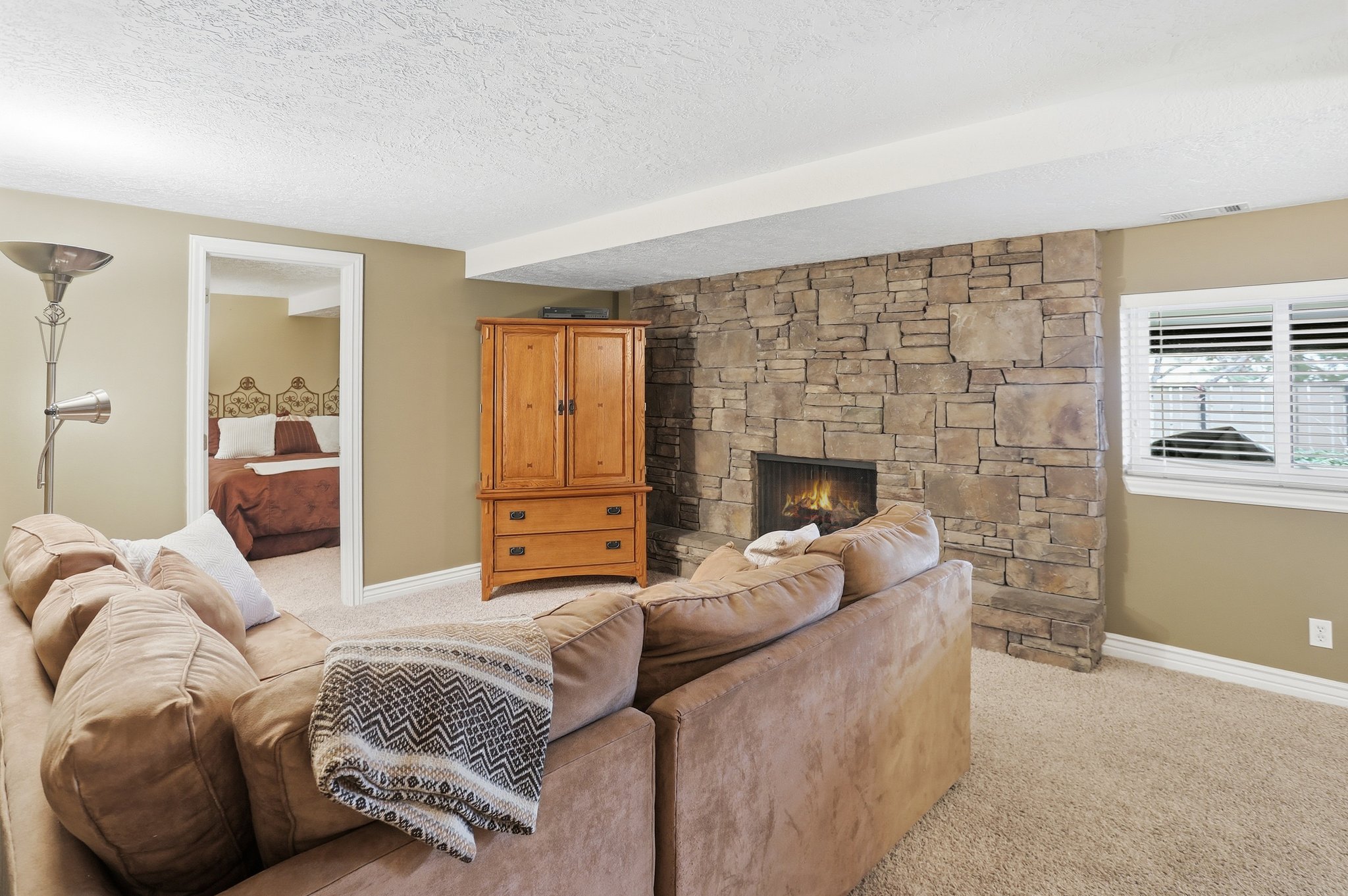 Living room featuring a fireplace, light carpet, and a textured ceiling