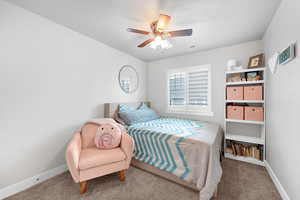 Carpeted bedroom with baseboards and a ceiling fan