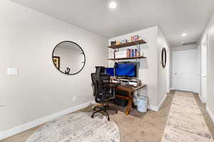 Home office with light carpet and recessed lighting