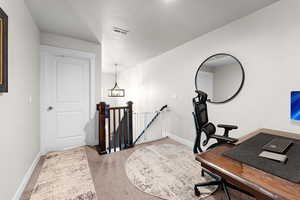 Office space with light carpet and baseboards