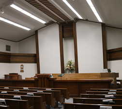 Chapel room featuring vaulted ceiling, raised dais, and installed benches