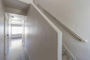Hall featuring stairs and wood finished floors