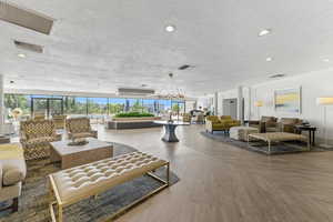 Lobby featuring a textured ceiling, recessed lighting, ornamental molding, and floor to ceiling windows
