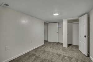 Unfurnished bedroom featuring light carpet and a closet