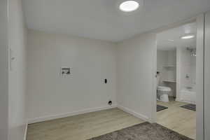 Washroom featuring light LVP flooring and hookup for a washing machine and dryer